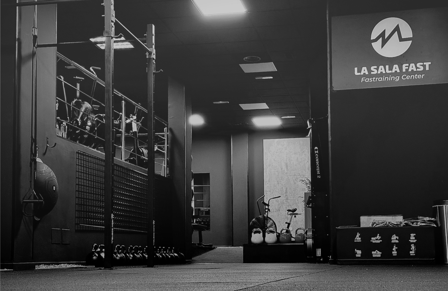 Sala de entrenamiento con pesas y una persona entrenando en Fast Training Center
